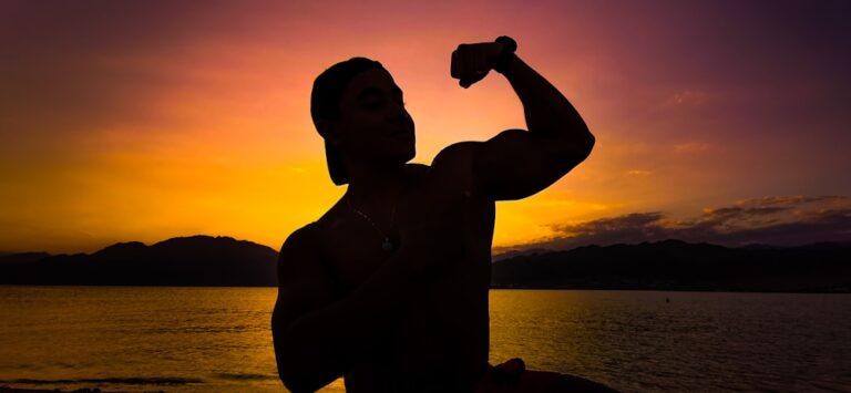 a man holding a bottle of water in front of a sunset