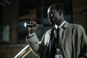 man in beige coat holding a flashlight