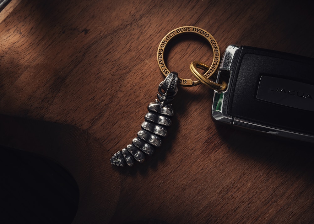 a camera and a keychain on a wooden table
